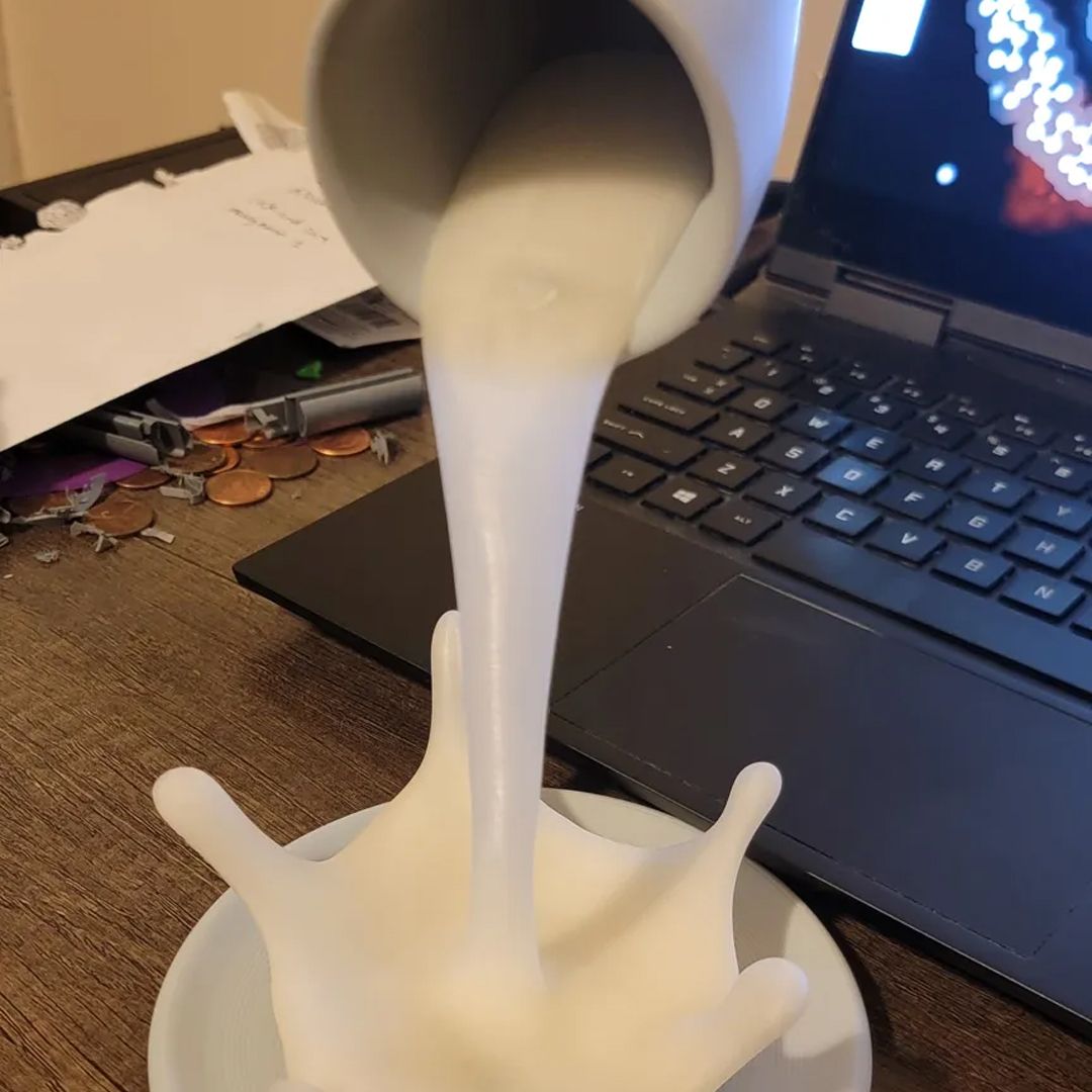A flooting 3D printd coffee splush near a laptop