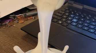 A flooting 3D printd coffee splush near a laptop