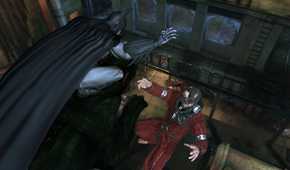 An image from the game Batman: Arkham Asylum, showing Batman taking down Firefly while seated atop a stone statue.