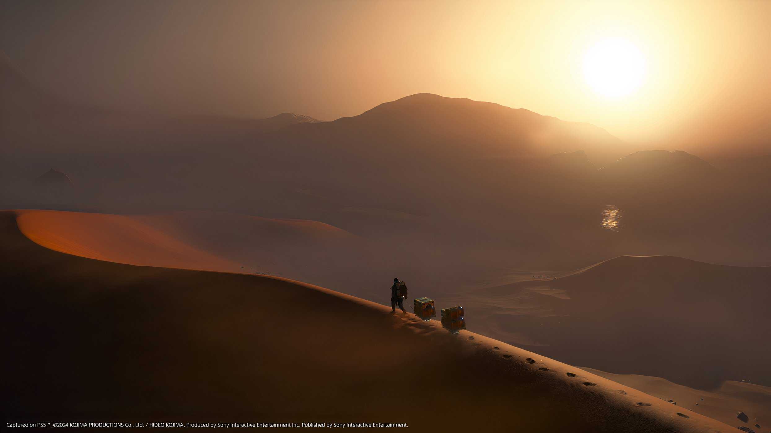 An image from the game Death Stranding 2: On The Beach, showing Sam walking along a sand dune as the sun sets.