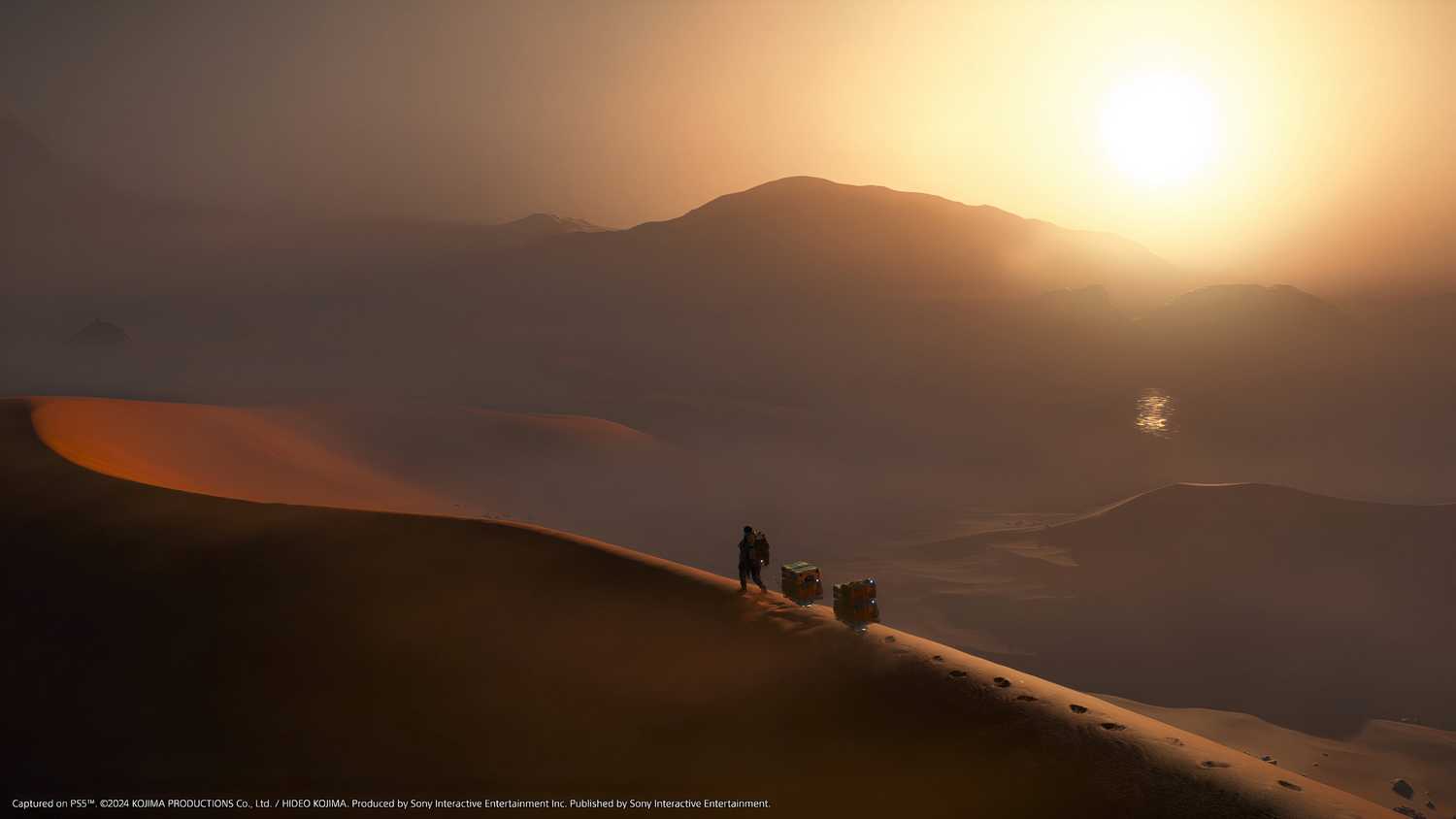 An image from the game Death Stranding 2: On The Beach, showing Sam walking along a sand dune as the sun sets.