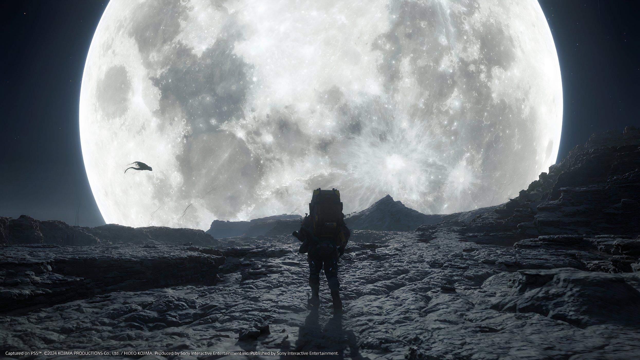 An image from the game Death Stranding 2: On The Beach, showing Sam's silhoutte against a huge, bright white moon.