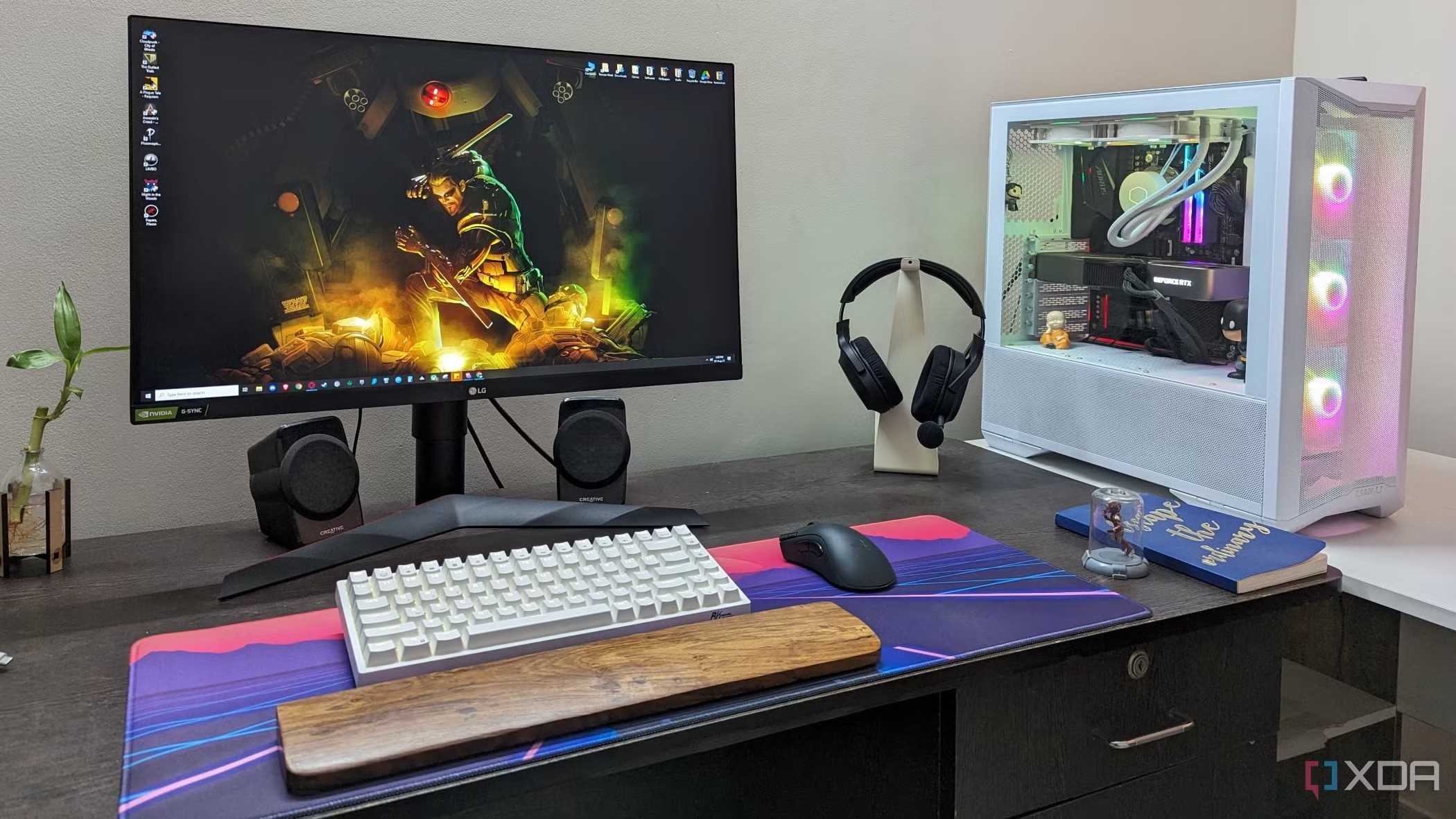 A desktop PC setup with a large mouse pad, keyboard, mouse and headphone on the desk
