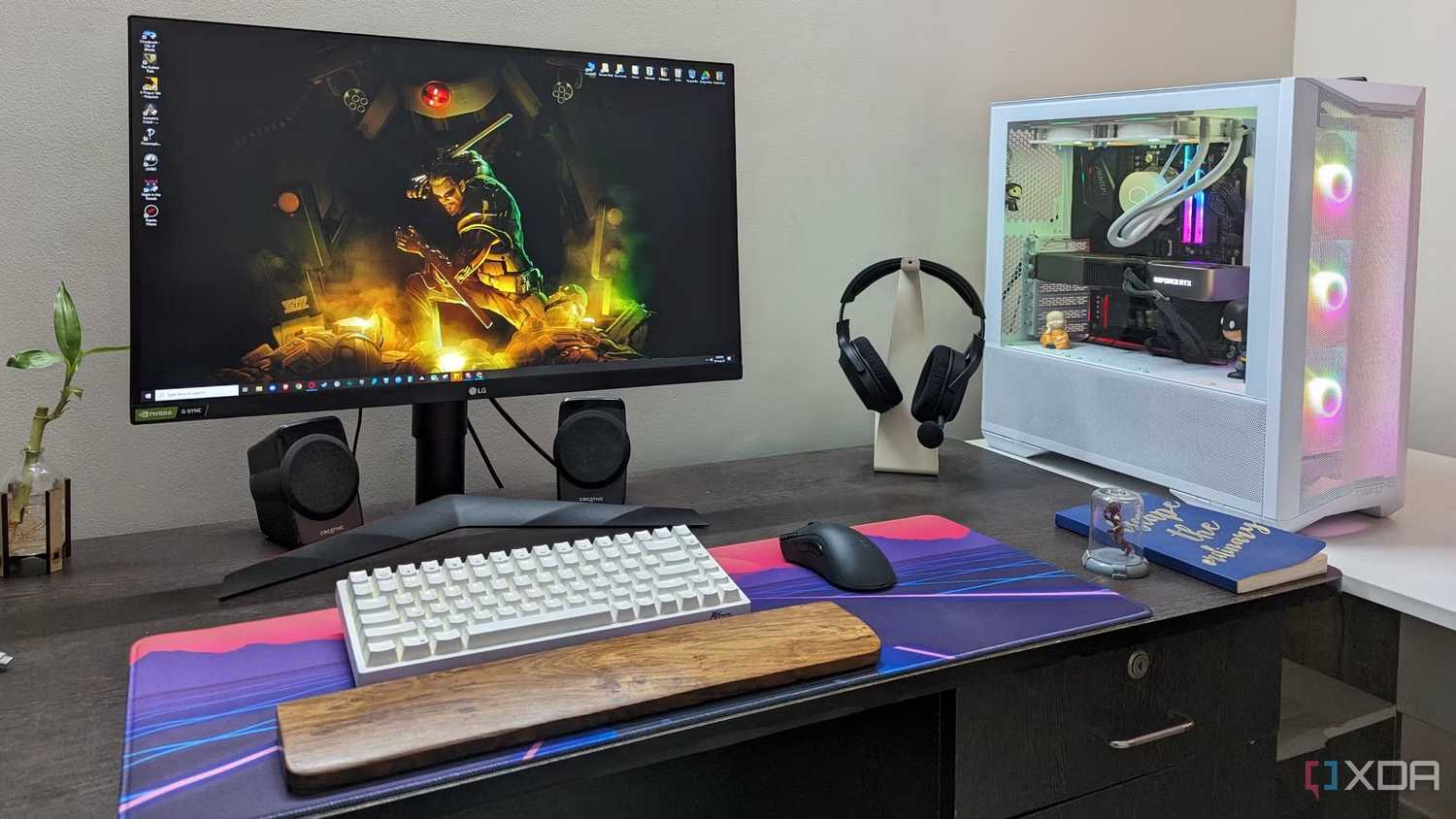 A desktop PC setup with a large mouse pad, keyboard, mouse and headphone on the desk
