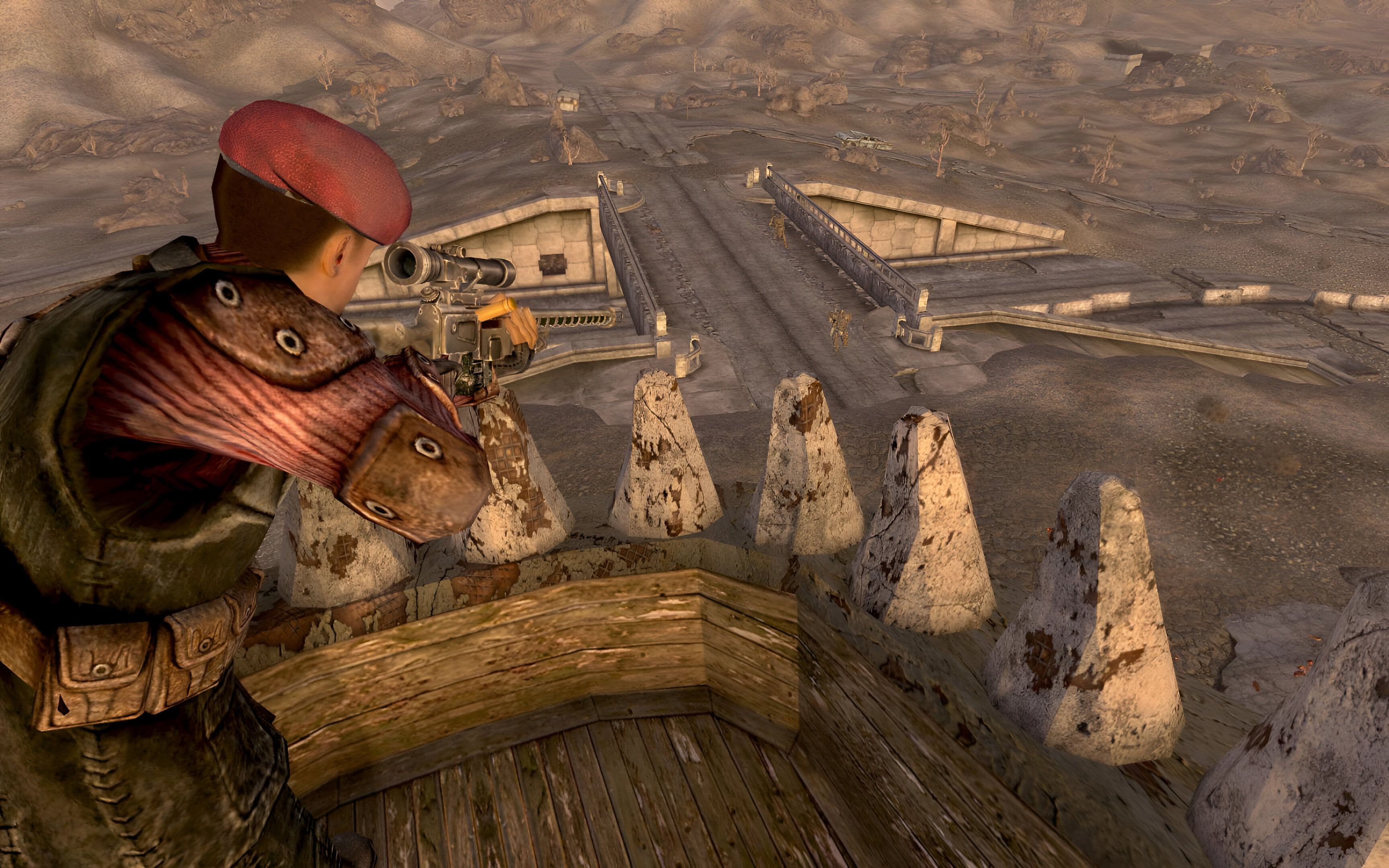An image from the game Fallout: New Vegas, showing a man in uniform perched atop a lookout, aiming down with a sniper.