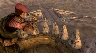 An image from the game Fallout: New Vegas, showing a man in uniform perched atop a lookout, aiming down with a sniper.