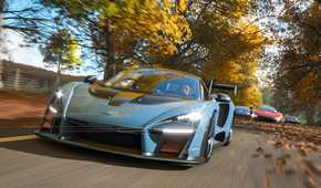 A screenshot from the game "Forza Horizon 4", showing a blue McLaren Senna racing against its competitors during fall season.