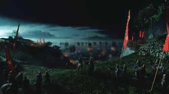 An image from Ghost of Tsushima, showing samurai lining up near a beach with their banners raised high.