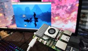 A photo of person holding a Raspberry Pi in front of a monitor