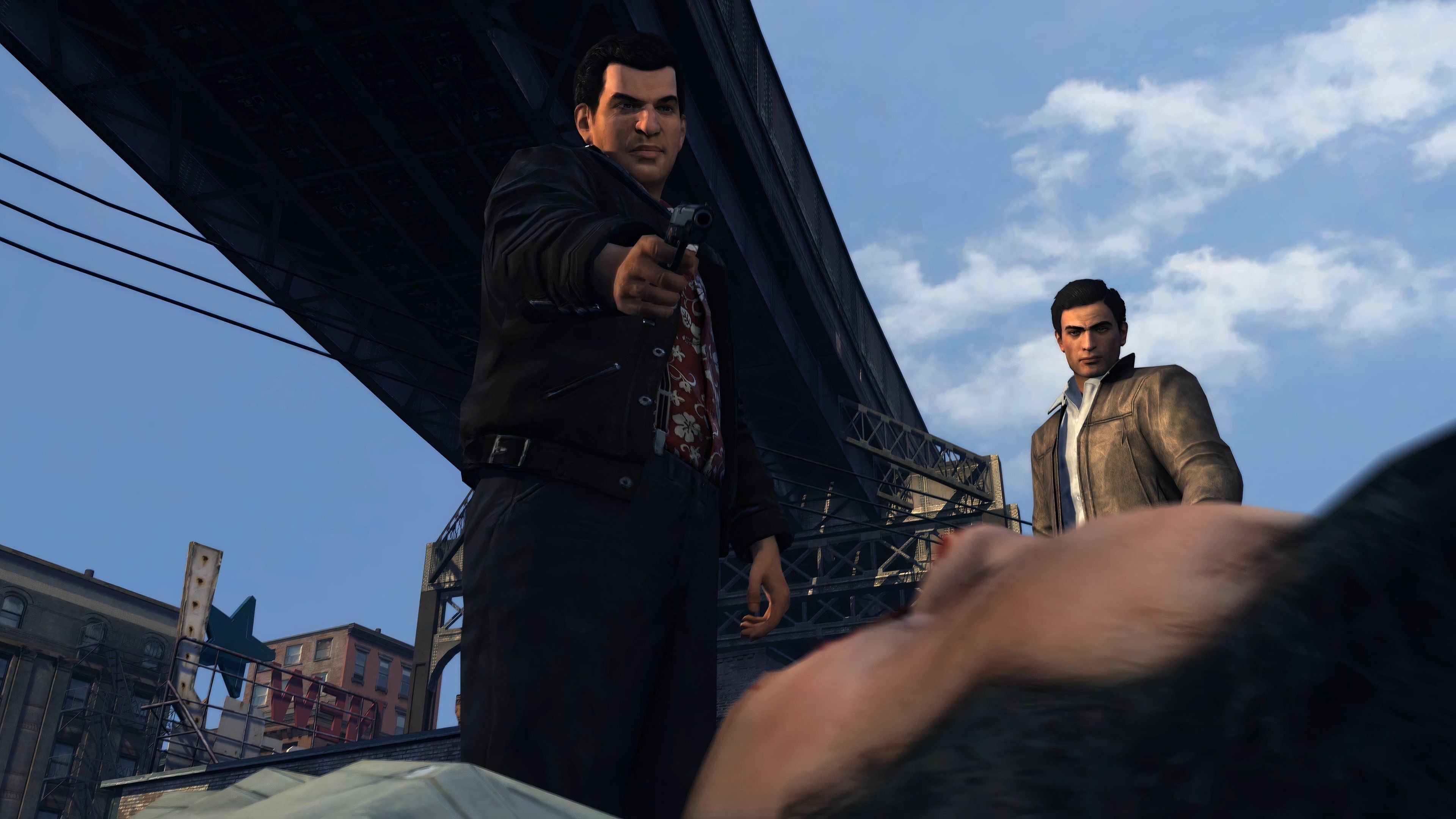 An image from the 2020 remaster of Mafia II, showing a man holding a gun over another person on the ground.