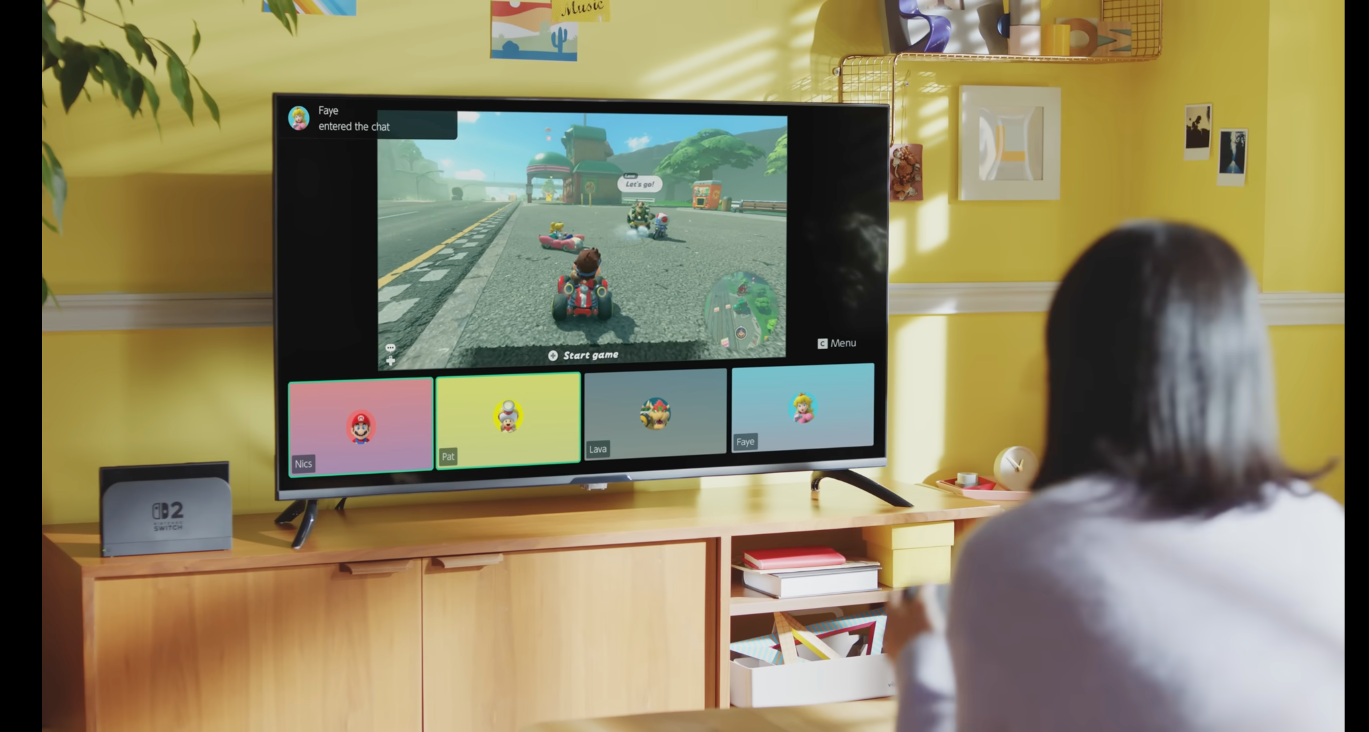 A womman sitting looking at a TV displaying a Nintendo Switch 2 game with the GameChat interface