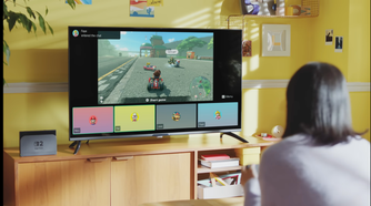 A womman sitting looking at a TV displaying a Nintendo Switch 2 game with the GameChat interface