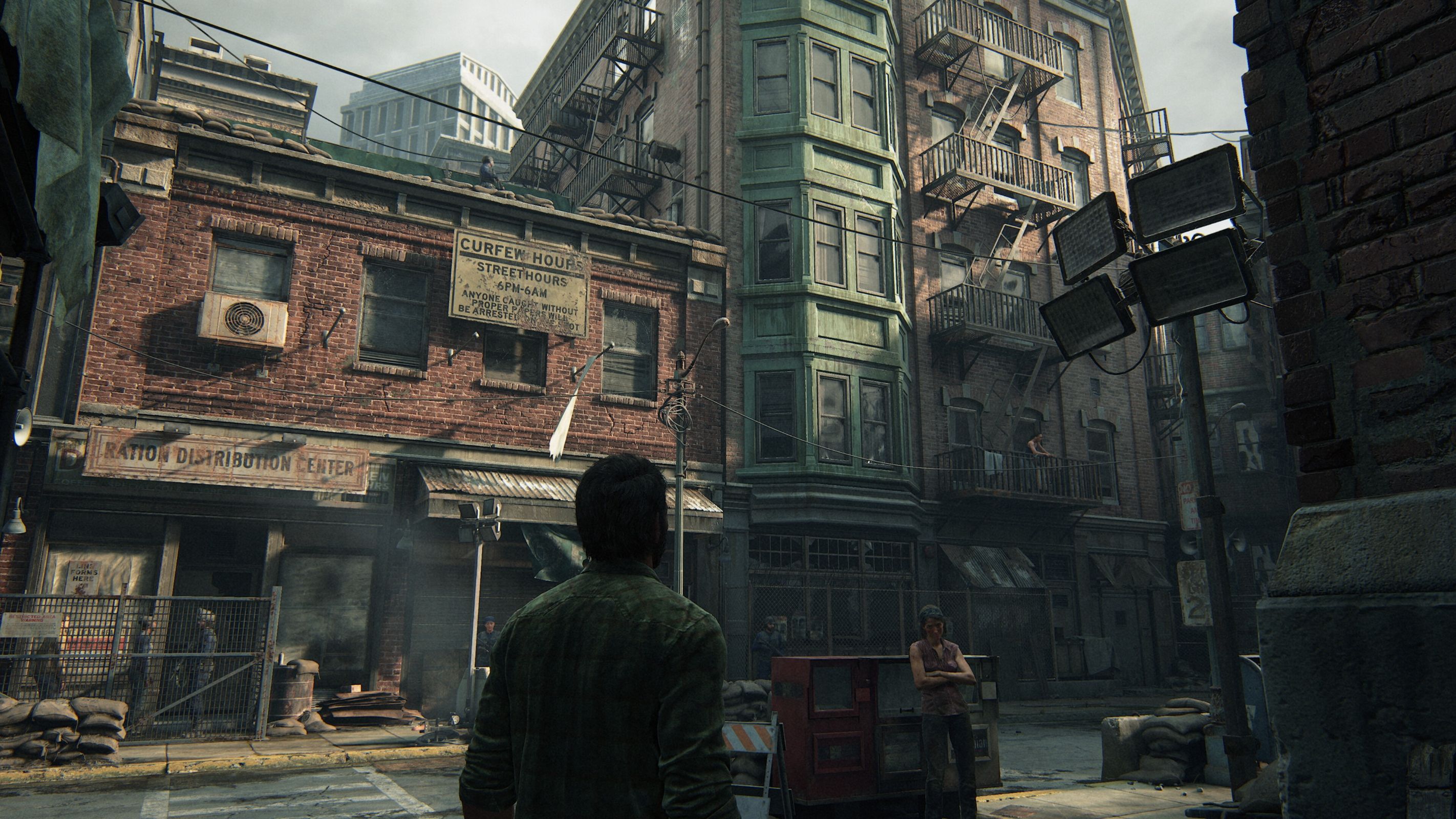 A screenshot from The Last of Us Part I on PC, showing Joel looking at the Boston quarantine zone.