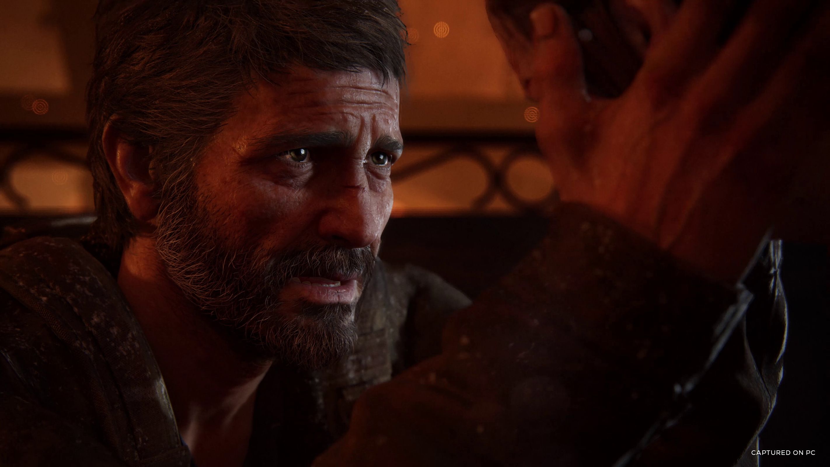 A screenshot from The Last of Us Part I on PC, showing Joel emotionally holding Ellie's face in his hands.