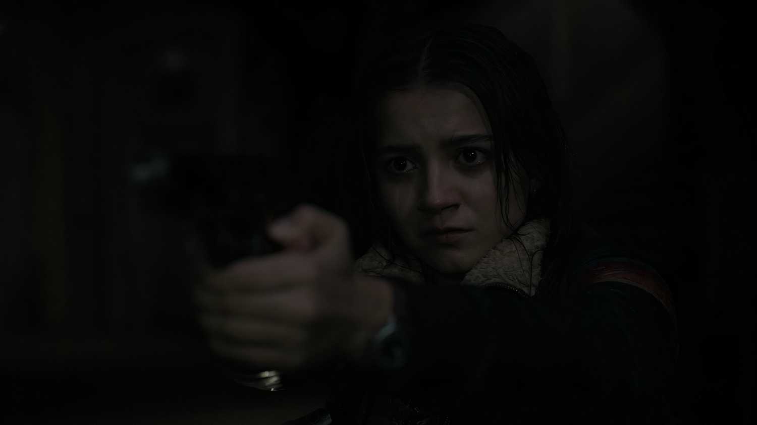 A screengrab from episode 4 of the HBO show The Last of Us Season 2, showing Dina aiming a gun at Ellie.