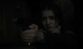 A screengrab from episode 4 of the HBO show The Last of Us Season 2, showing Dina aiming a gun at Ellie.