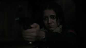 A screengrab from episode 4 of the HBO show The Last of Us Season 2, showing Dina aiming a gun at Ellie.