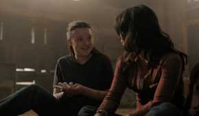 A screengrab from episode 4 of the HBO show The Last of Us Season 2, showing Ellie and Dina smiling at each other.