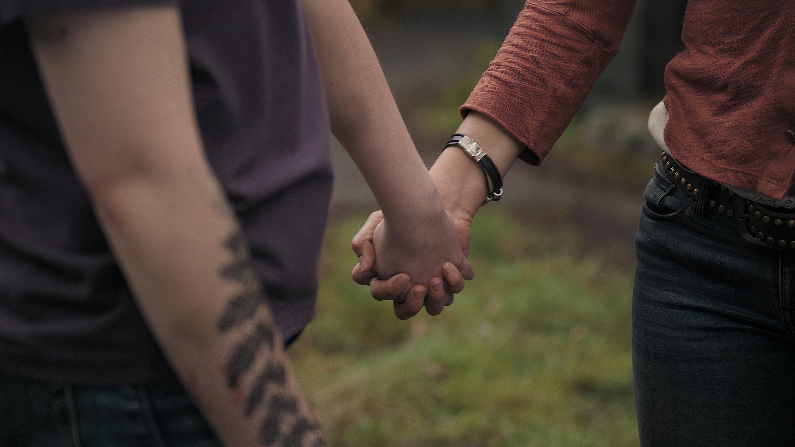 A screengrab from episode 4 of the HBO show The Last of Us Season 2, showing Ellie and Dina holding hands.