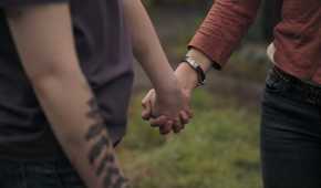 A screengrab from episode 4 of the HBO show The Last of Us Season 2, showing Ellie and Dina holding hands.