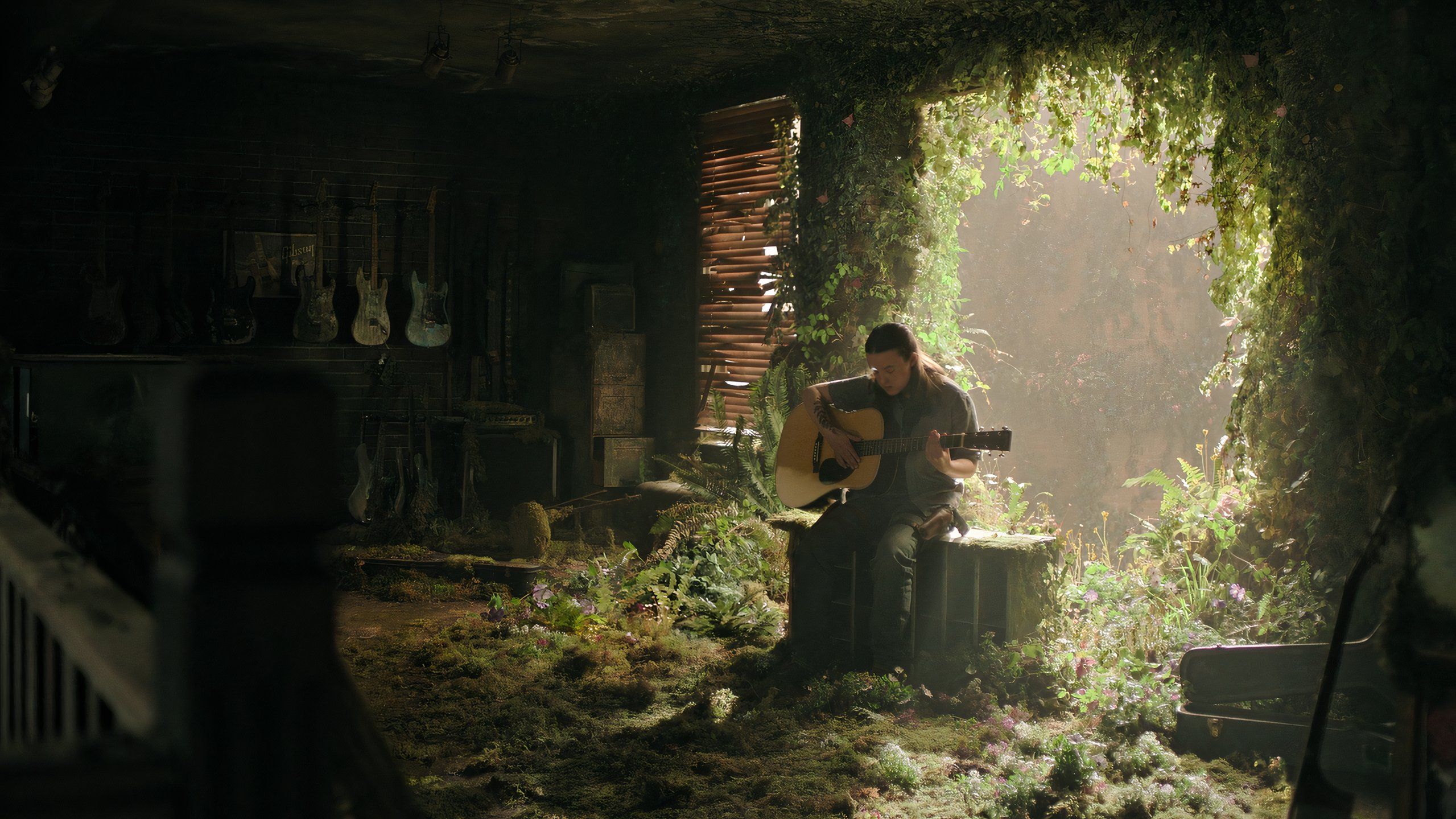 A screengrab from episode 4 of the HBO show The Last of Us Season 2, showing Ellie playing a guitar while seated in sunlight.
