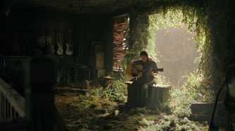 A screengrab from episode 4 of the HBO show The Last of Us Season 2, showing Ellie playing a guitar while seated in sunlight.