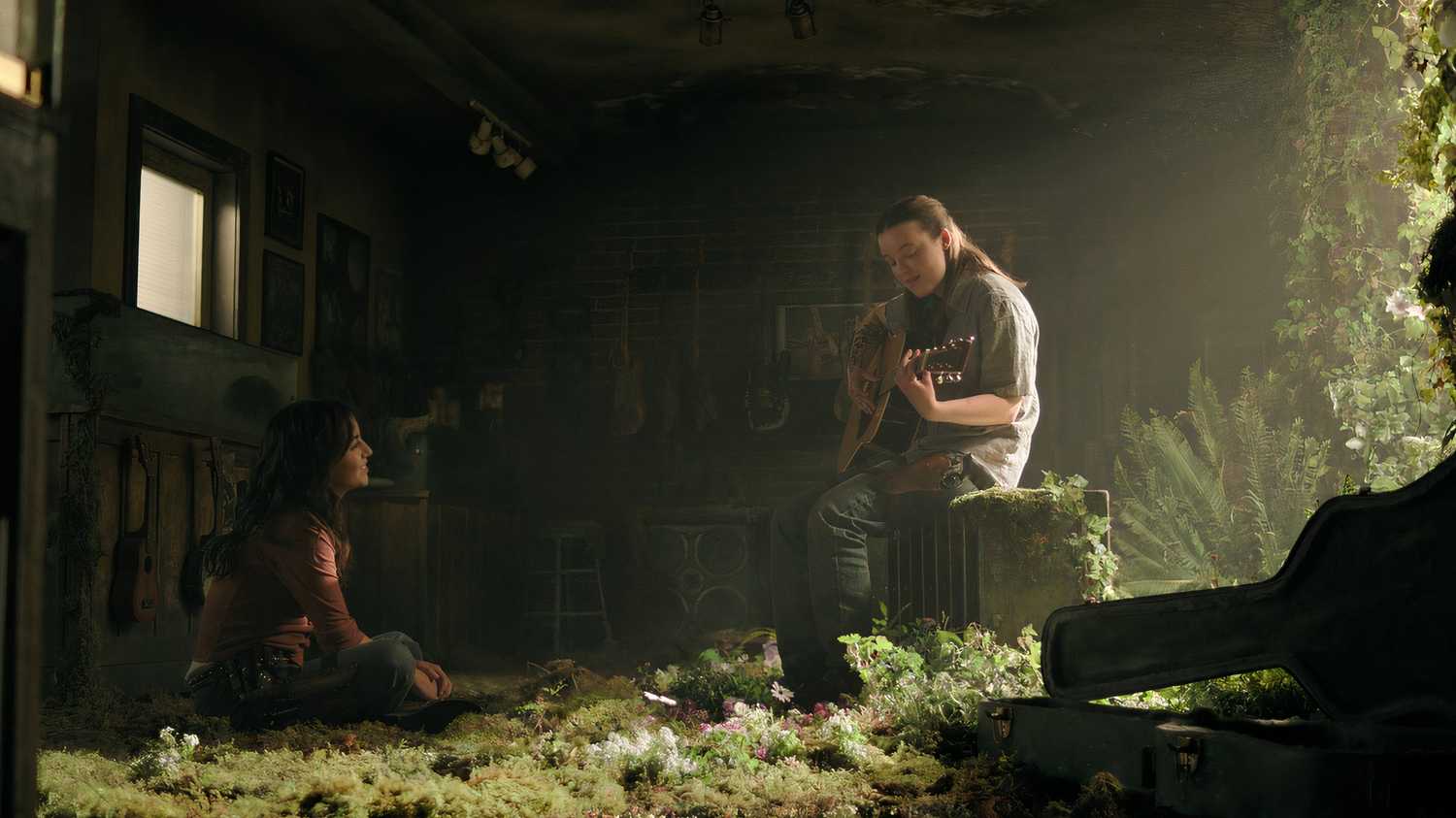A screengrab from episode 4 of the HBO show The Last of Us Season 2, showing Ellie playing the guitar for Dina.