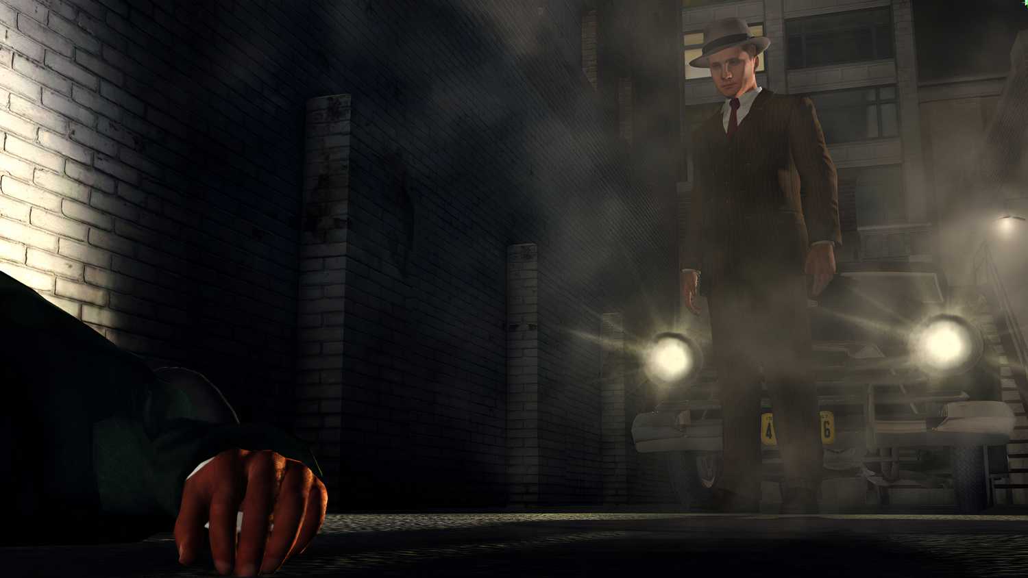 Cole Phelps standing in front of a car with its headlights on in L.A. Noire.