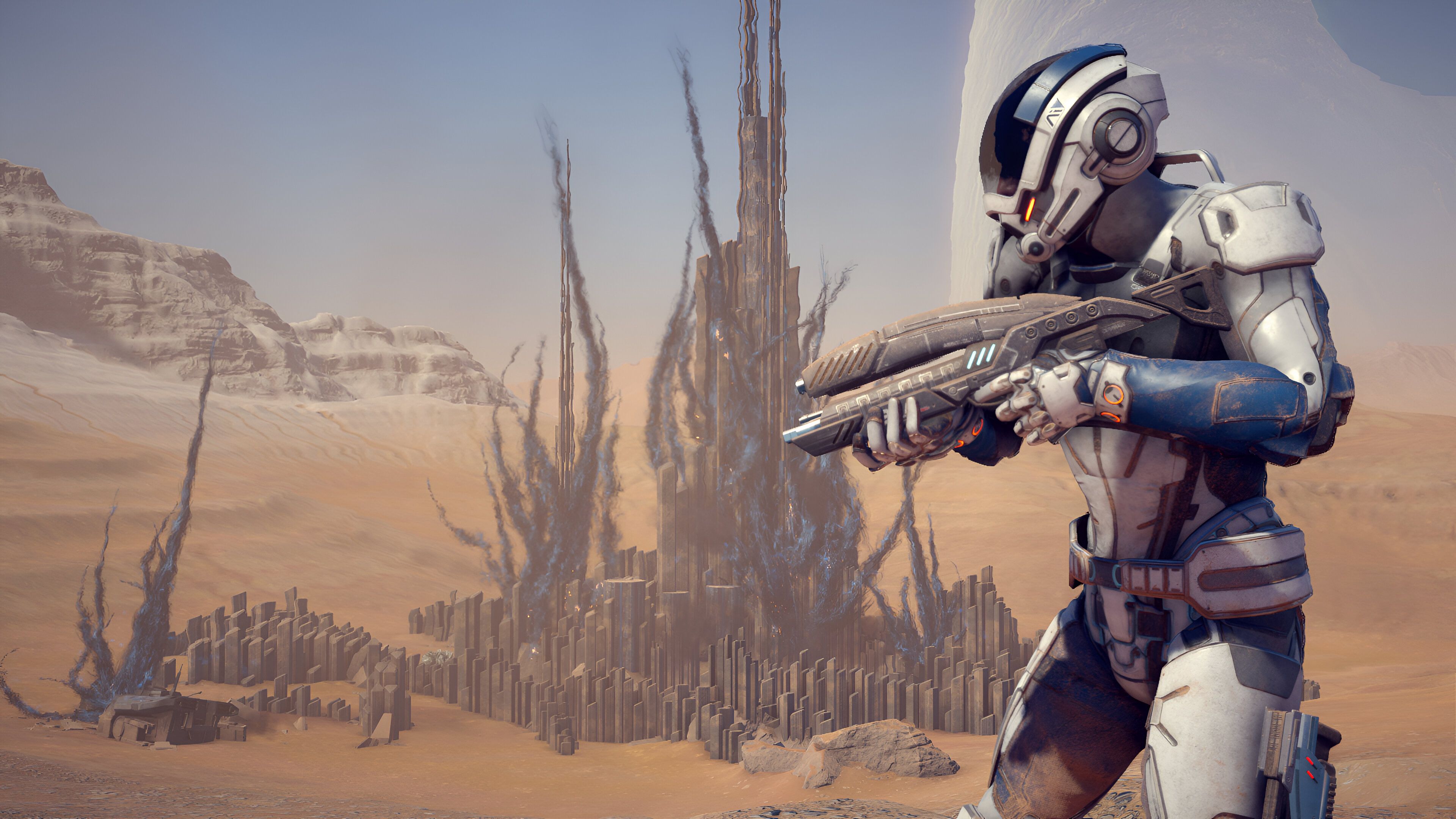 A character holding a gun in a desert landscape in Mass Effect: Andromeda.