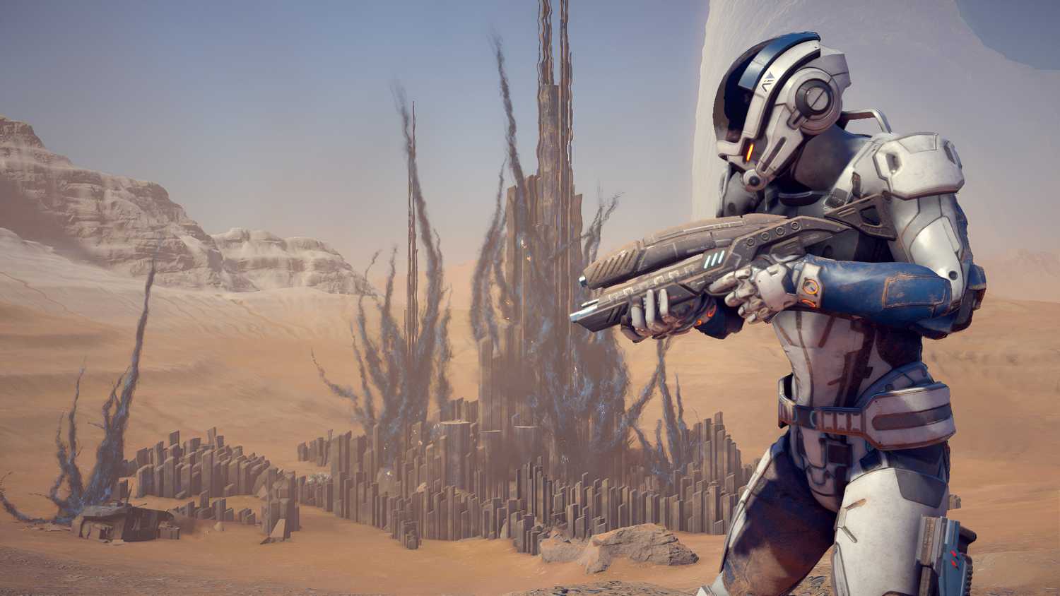A character holding a gun in a desert landscape in Mass Effect: Andromeda.