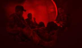 Martin Walker and his comrades sitting together, bathed in red light, in Spec Ops: The Line.