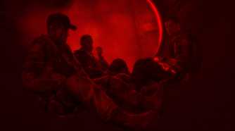 Martin Walker and his comrades sitting together, bathed in red light, in Spec Ops: The Line.