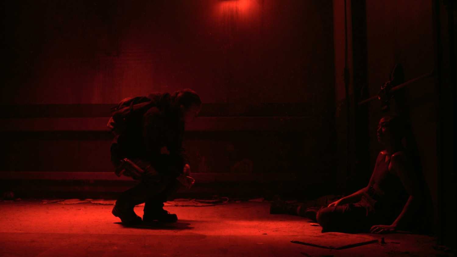 Ellie crouching in front of Nora in HBO's The Last of Us, season 2, episode 5.