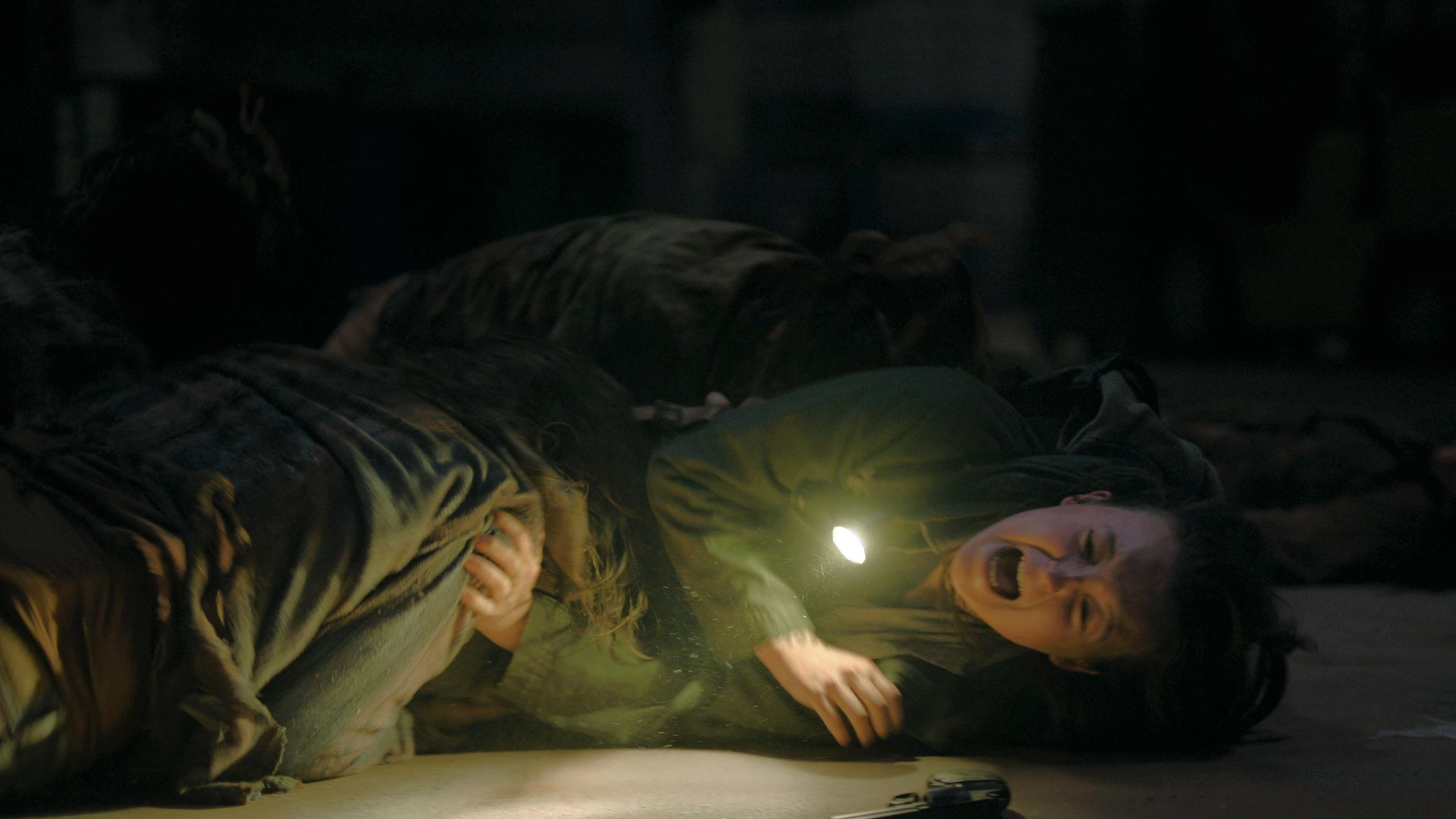 Ellie pinned down by stalkers in HBO's The Last of Us, season 2, episode 5.