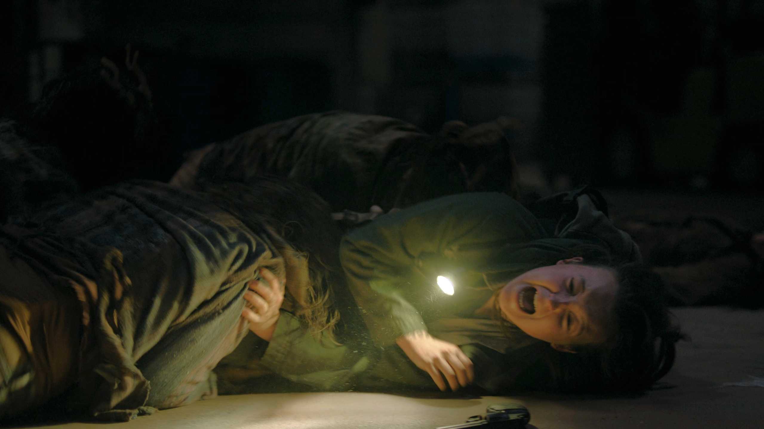 Ellie pinned down by stalkers in HBO's The Last of Us, season 2, episode 5.