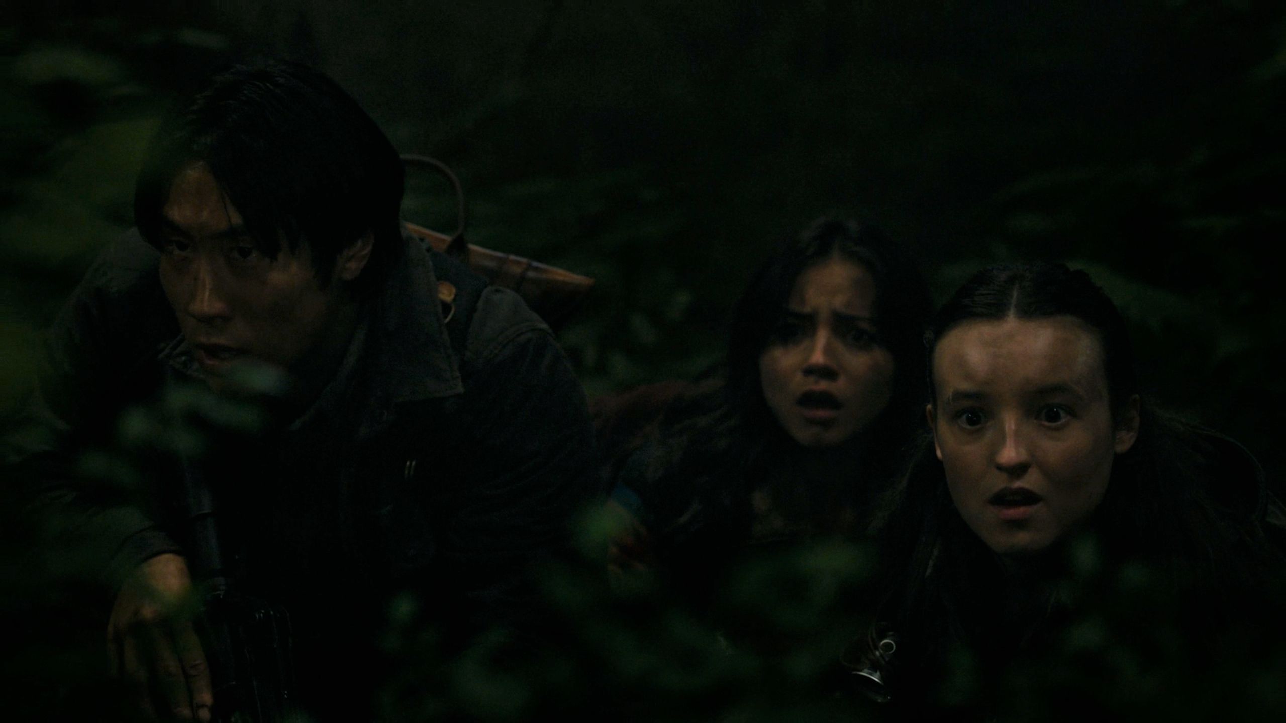 Jesse, Dina, and Ellie looking afraid while hiding in HBO's The Last of Us, season 2, episode 5.
