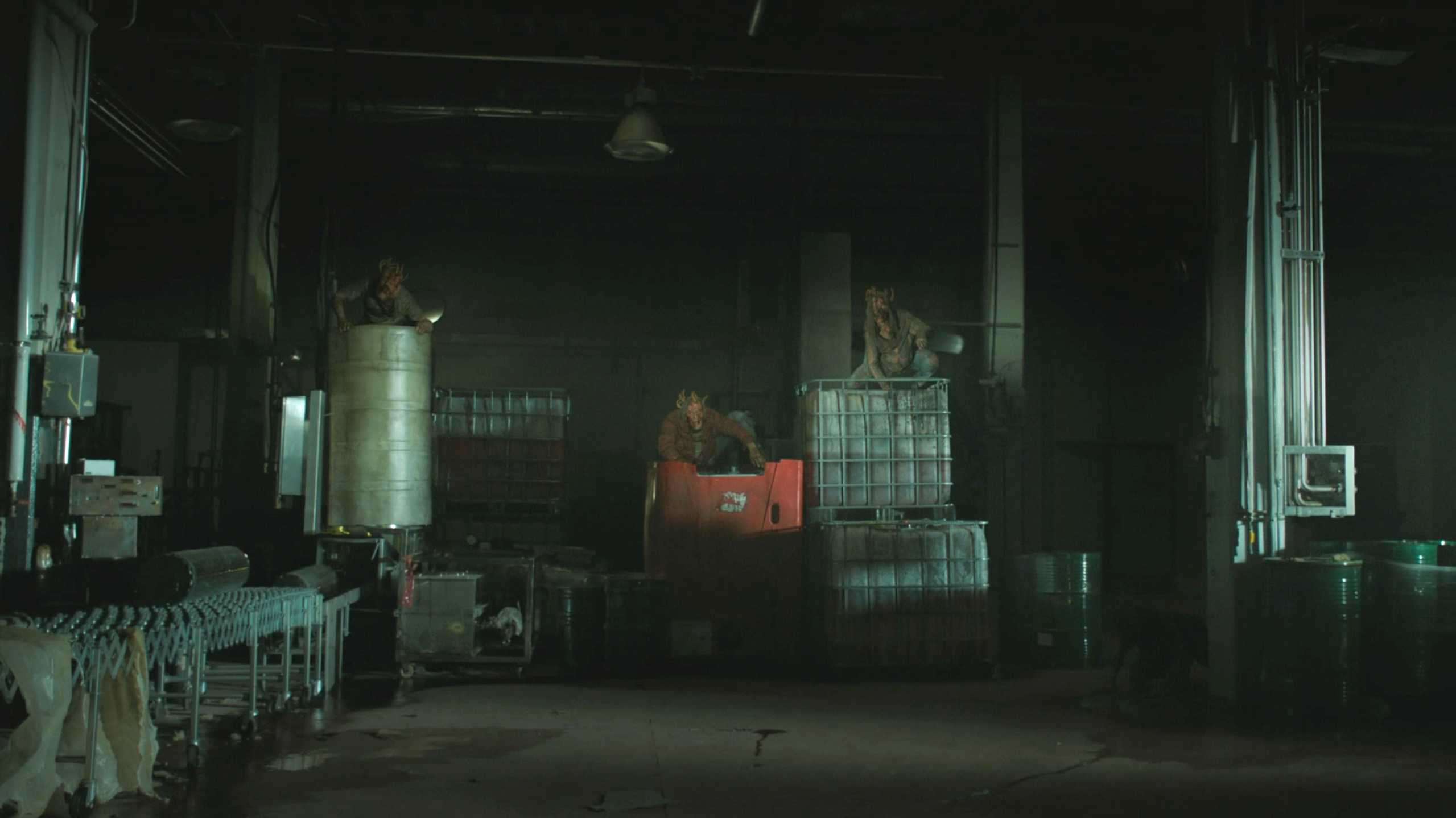 Mutliple stalkers sitting atop crates in HBO's The Last of Us, season 2, episode 5.