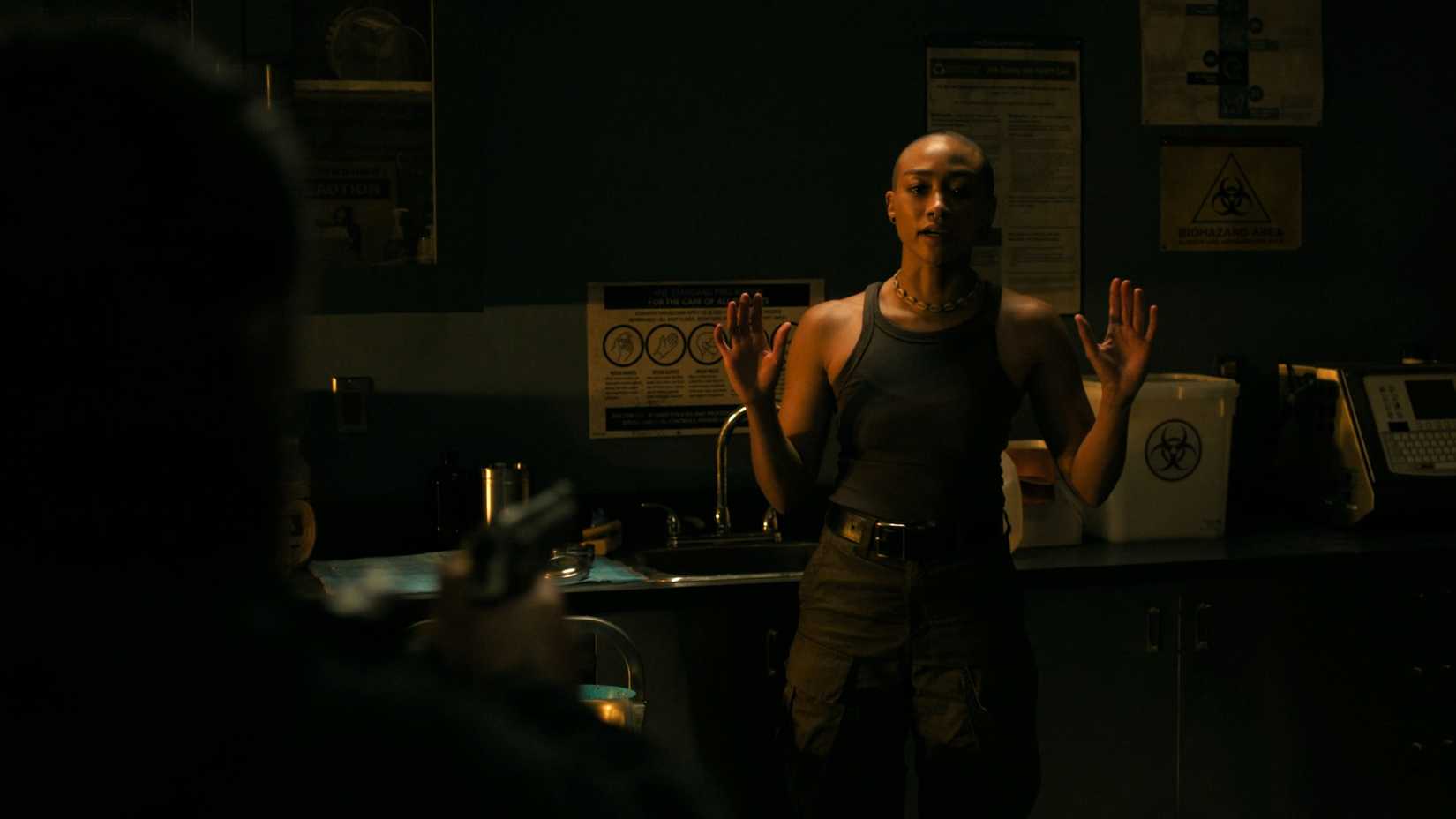 Ellie holding Nora up at gunpoint in HBO's The Last of Us, season 2, episode 5.
