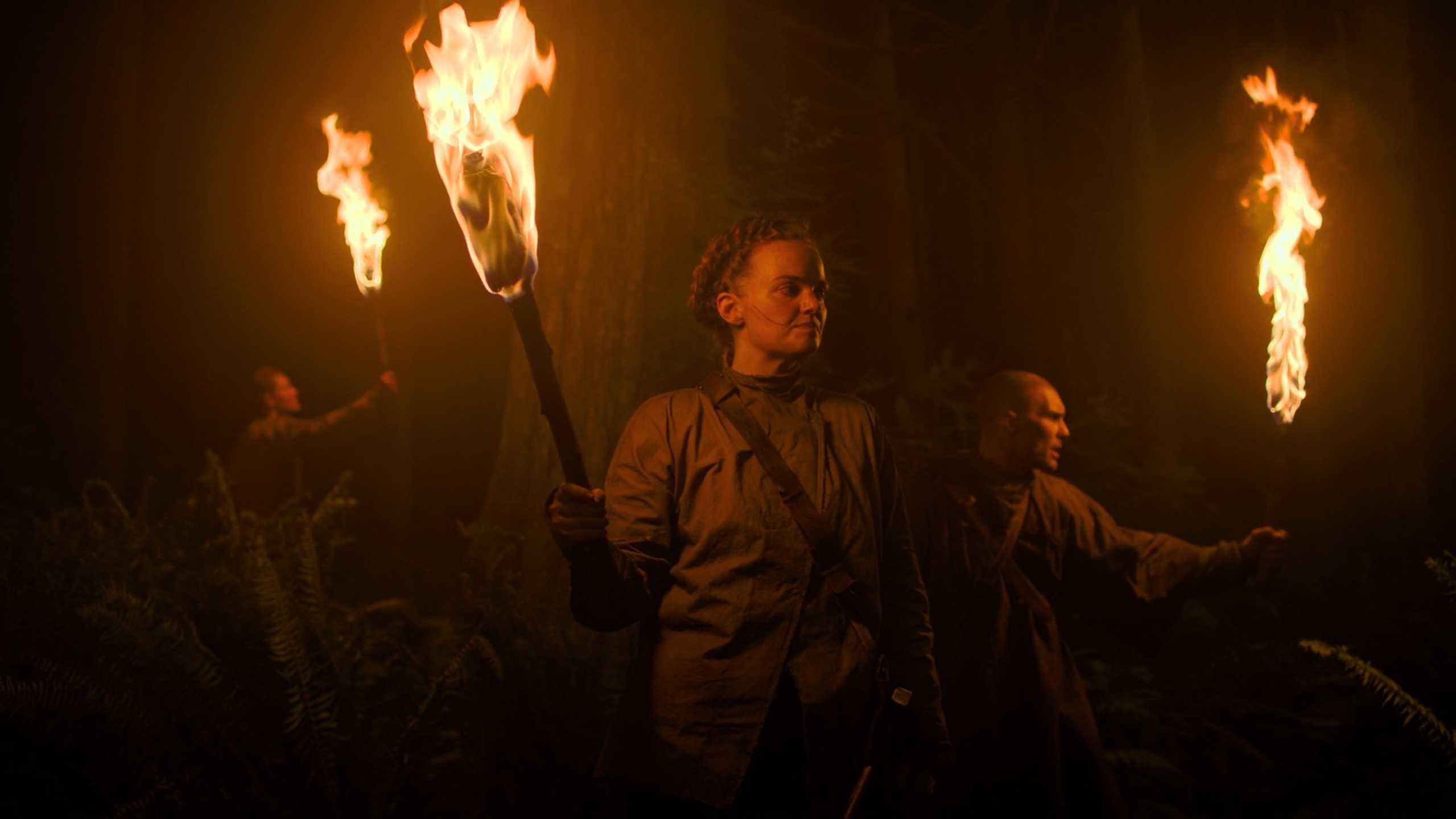 Seraphites holding flaming torches in HBO's The Last of Us, season 2, episode 5.