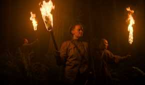 Seraphites holding flaming torches in HBO's The Last of Us, season 2, episode 5.