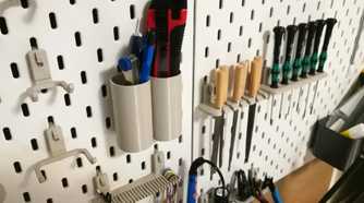 close-up shot of a box cutter and wood files in dedicated holders on an IKEA pegboard