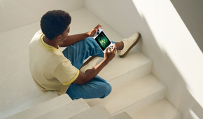 A man playing on the Xbox Ally in a stairwell