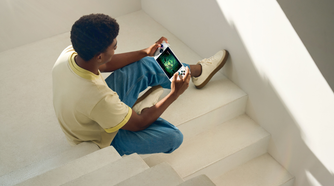 A man playing on the Xbox Ally in a stairwell