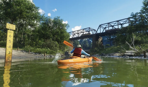 A man kayaking through a canal in GTA VI