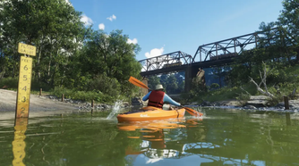 A man kayaking through a canal in GTA VI