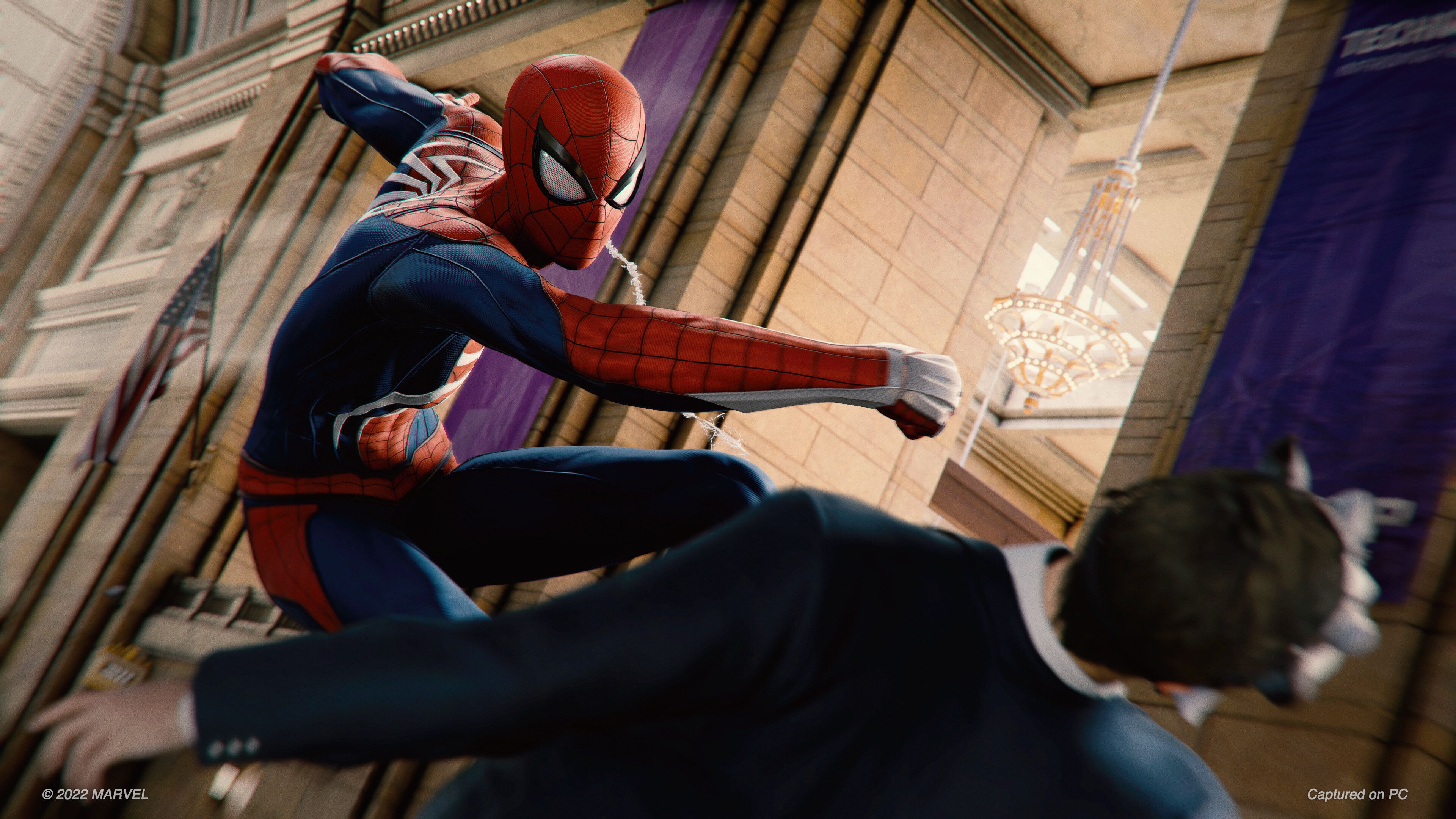 Spider-Man punching a bank robber in 2018's Spider-Man game by Insomniac.