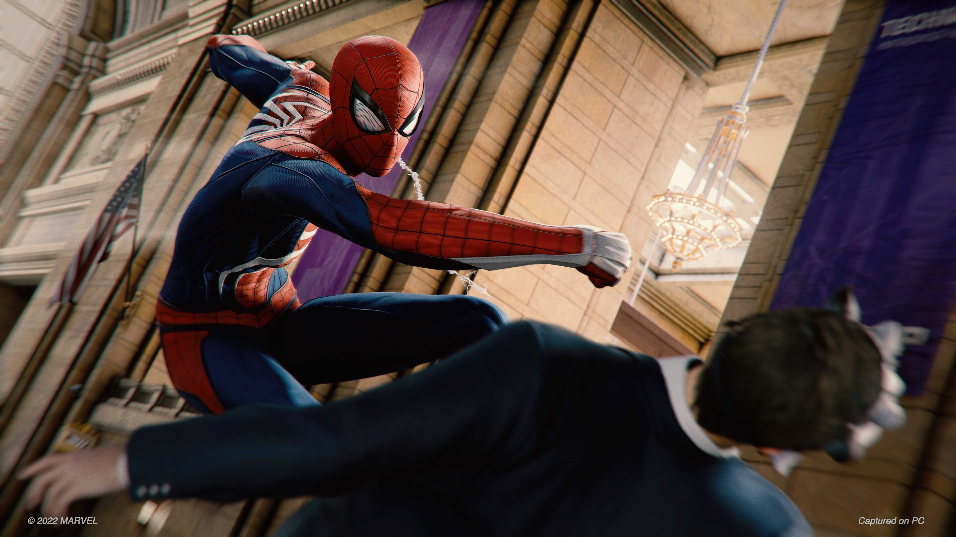 Spider-Man punching a bank robber in 2018's Spider-Man game by Insomniac.