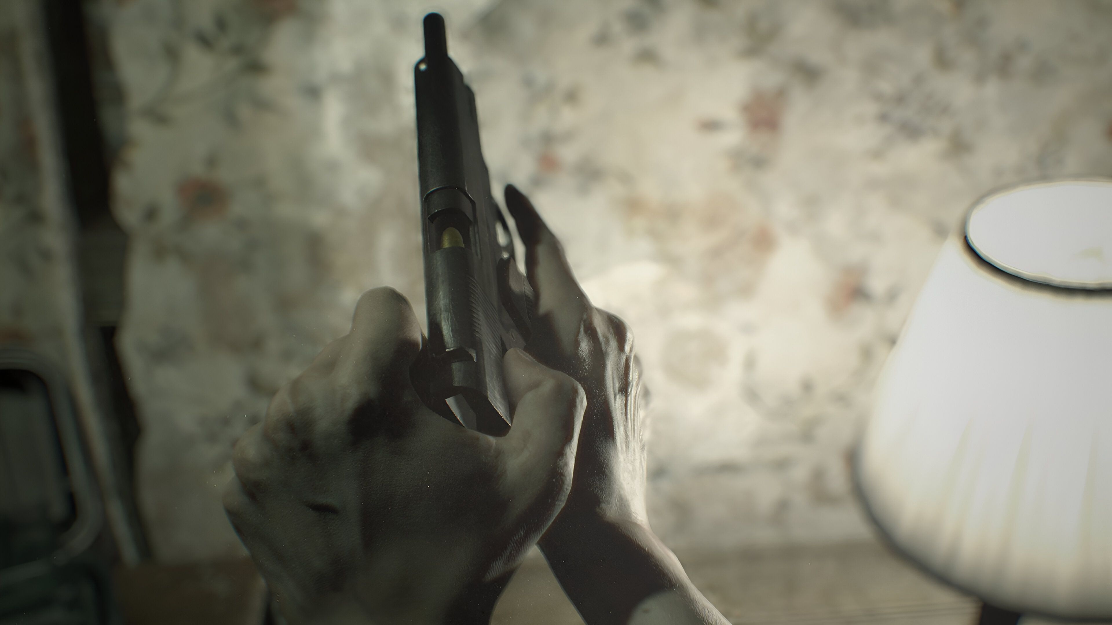 Ethan cocking a pistol in Resident Evil 7 (2017).