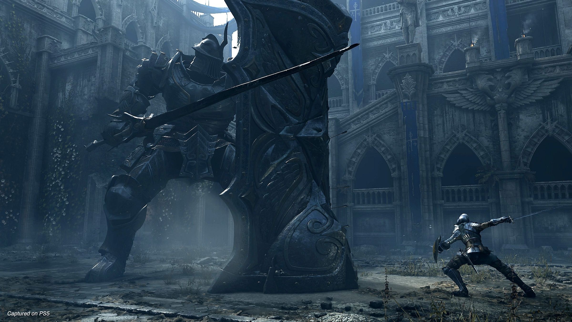 The player battling a huge knight in Demon's Souls.