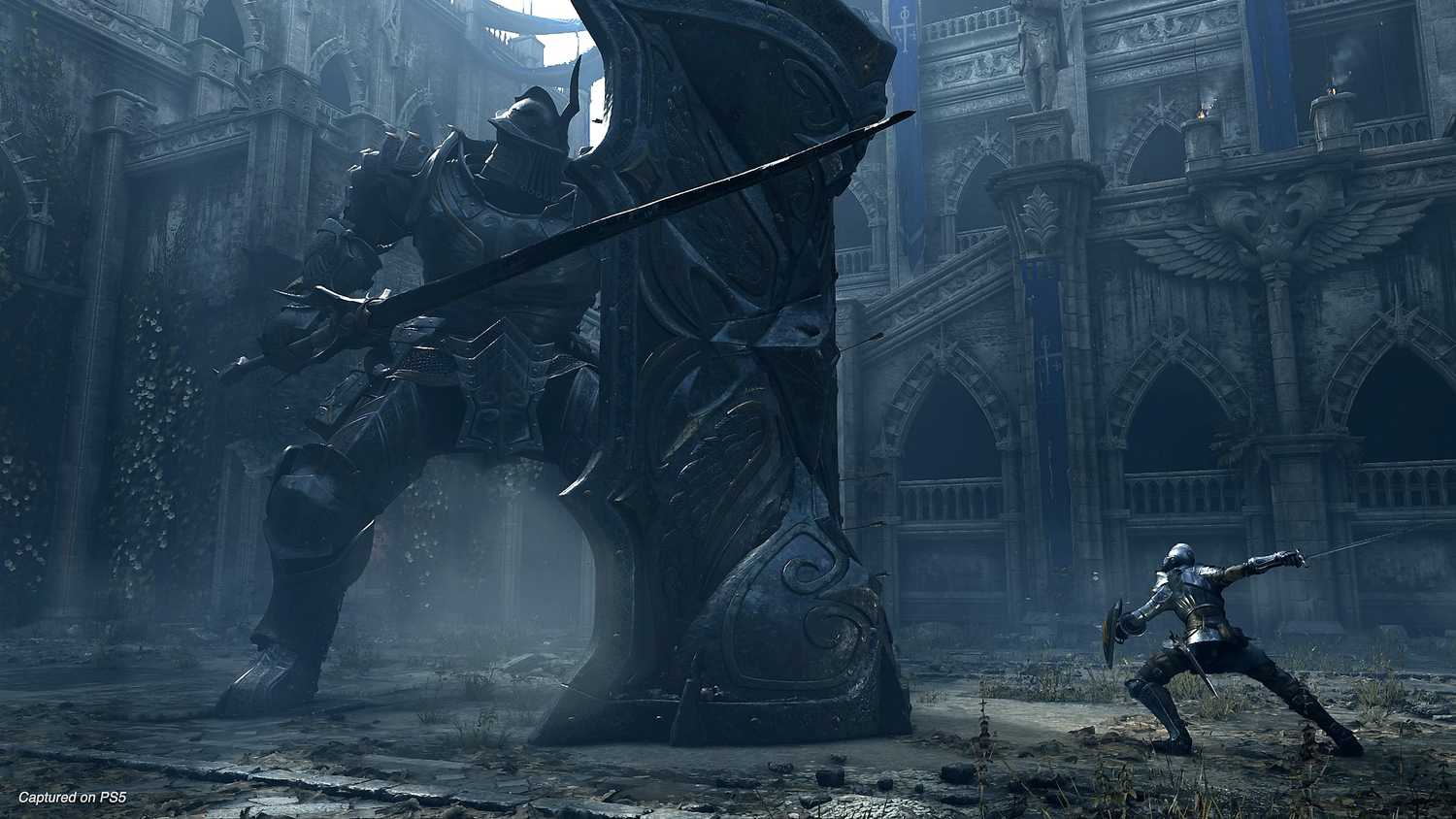 The player battling a huge knight in Demon's Souls.